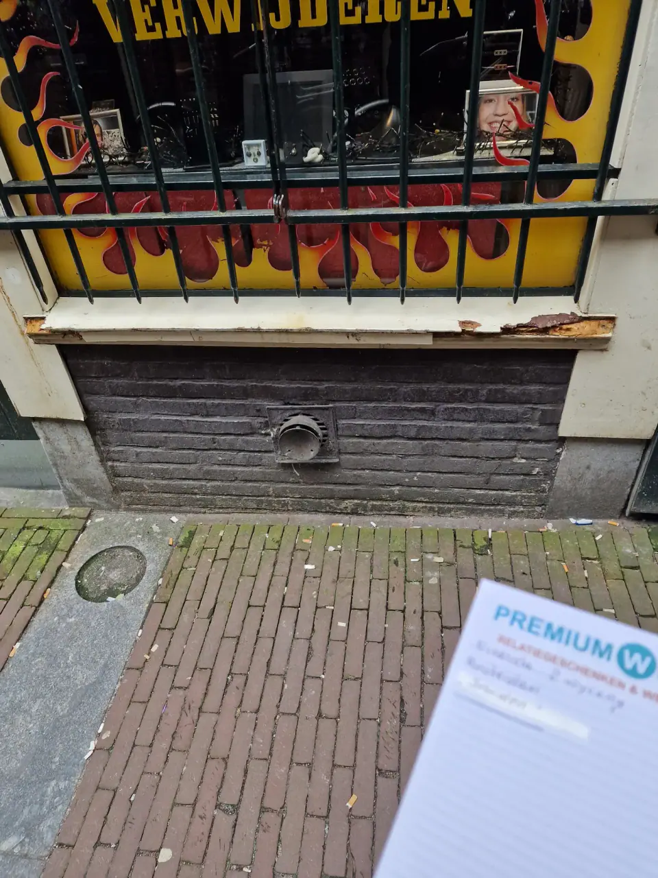 Houtschade onder het etalageraam van de winkelgevel
