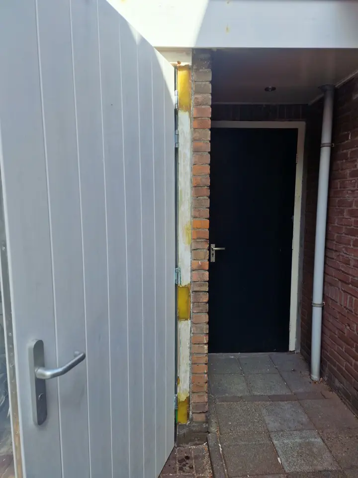 Herstelde houten aansluiting naast een buitendeur
