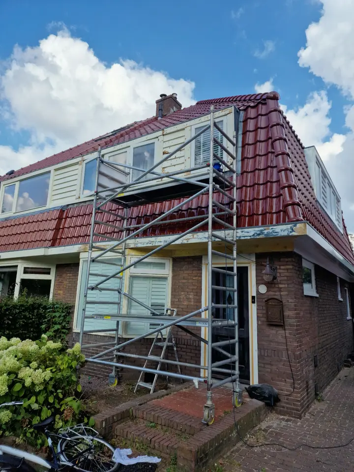 Woning in Beverwijk tijdens houtreparatie en schilderwerk met rolsteiger