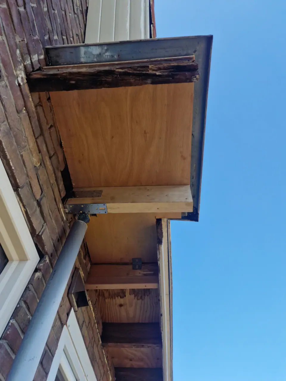 Nieuwe houten aftimmering aan de onderzijde van het overstek
